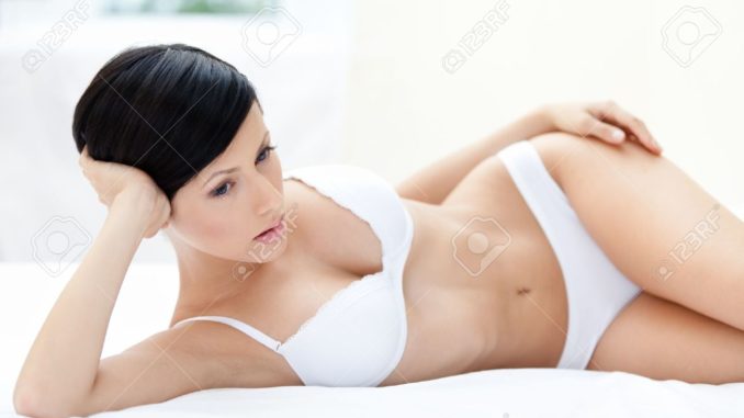15689945-woman-in-underwear-is-lying-in-the-soft-bed-white-background-stock-photo
